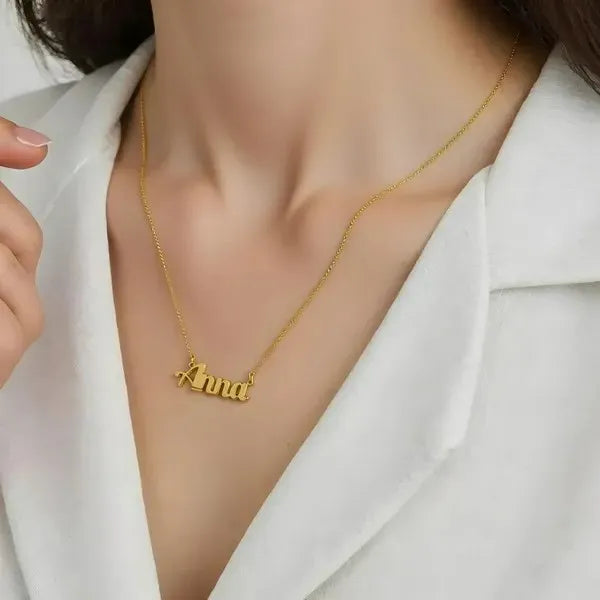 Model wearing 14 karat small bold print name necklace in yellow gold