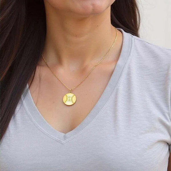 Baseball pendant worn by woman in yellow gold