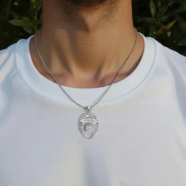 White gold EMT badge pendant worn by man