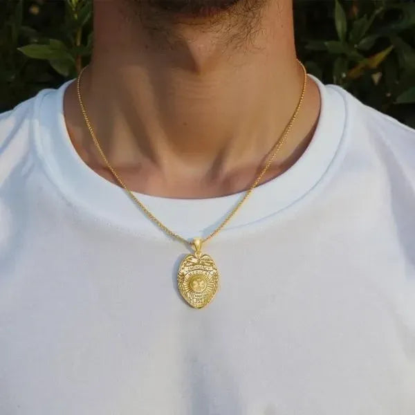 EMT badge pendant worn by man in yellow gold