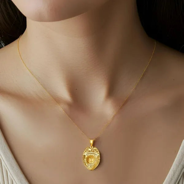 EMT badge pendant worn by woman in yellow gold