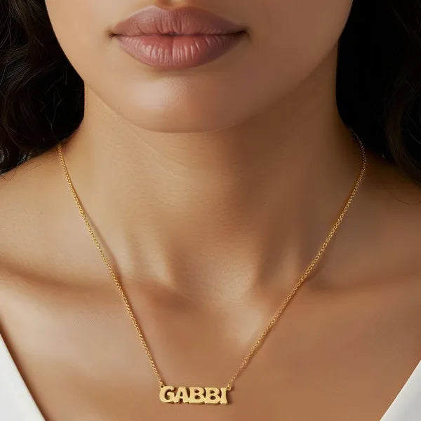 Model showcasing Gabbi retro letter name necklace yellow gold