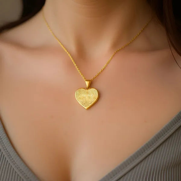 Heart shaped fingerprint charm pendant worn in yellow gold
