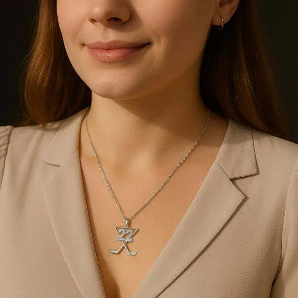 White gold hockey pendant worn by woman