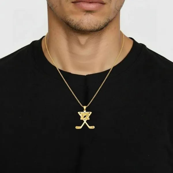 Hockey pendant worn by man in yellow gold