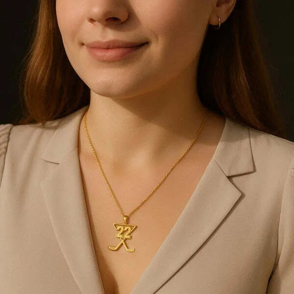 Hockey pendant worn by woman in yellow gold