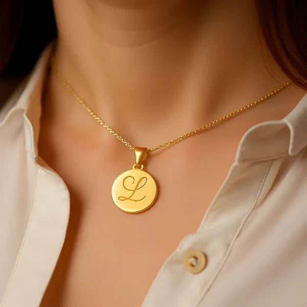 Initial disc pendant worn in yellow gold