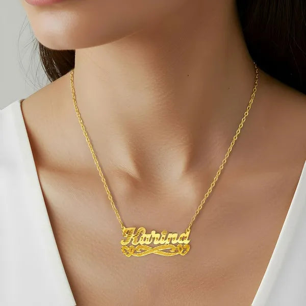 Karina name necklace worn in 14k yellow gold with heart detail