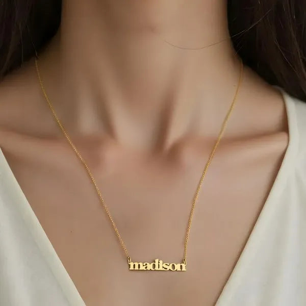 Model showcasing Madison bold name necklace yellow gold