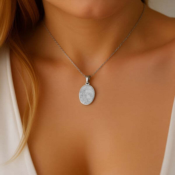 Oval fingerprint charm pendant worn in sterling silver