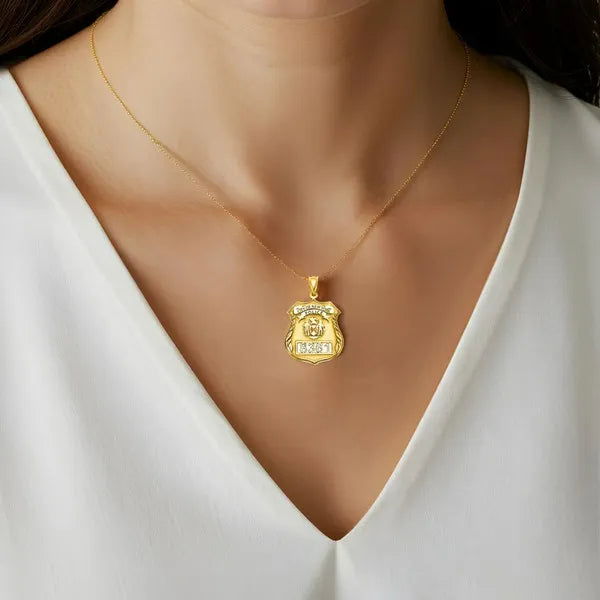 Police badge charm pendant worn by woman in yellow gold