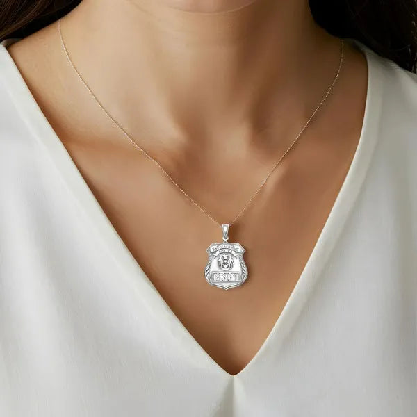 White gold police badge pendant worn by woman