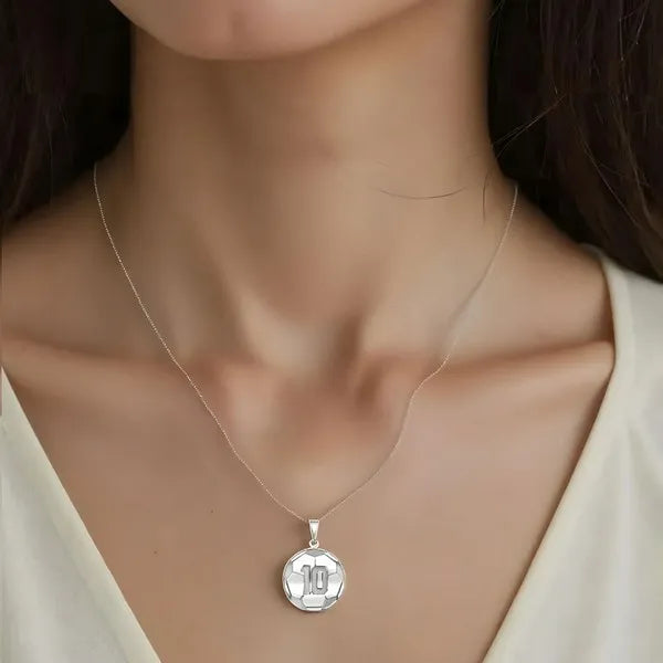 White gold soccer ball pendant worn by woman